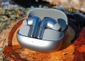 Xiaomi Buds 5 Pro placeret i opladningsetui på birkestamme i efterårssolen