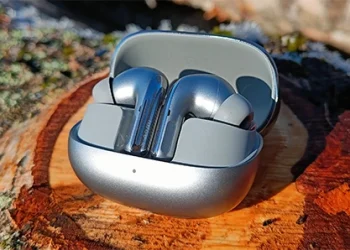 Xiaomi Buds 5 Pro placeret i opladningsetui på birkestamme i efterårssolen