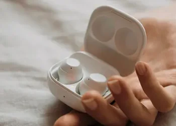 Hvide Samsung-in-ear-hovedtelefoner i et hvidt etui i en kvindehånd