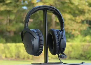 HyperX Cloud Stinger 3 placeret på hovedtelefonstativ med træer og buske i baggrunden
