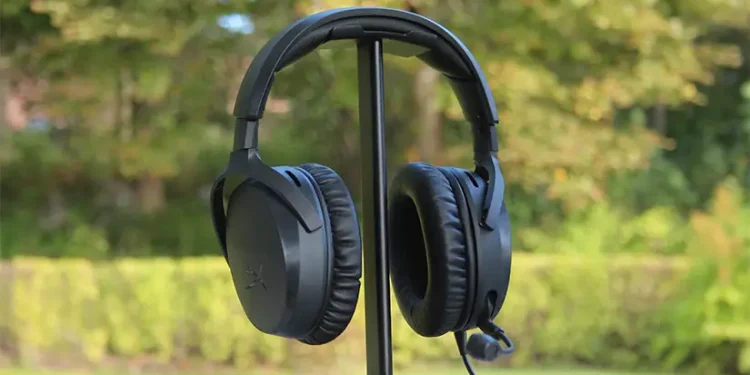 HyperX Cloud Stinger 3 placeret på hovedtelefonstativ med træer og buske i baggrunden