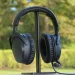 HyperX Cloud Stinger 3 placeret på hovedtelefonstativ med træer og buske i baggrunden